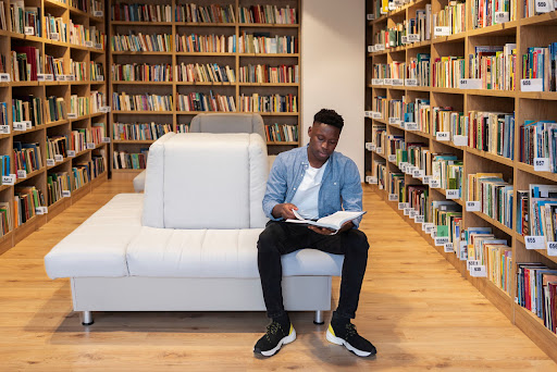 homem lendo em uma biblioteca para saber como funciona os direitos autorais