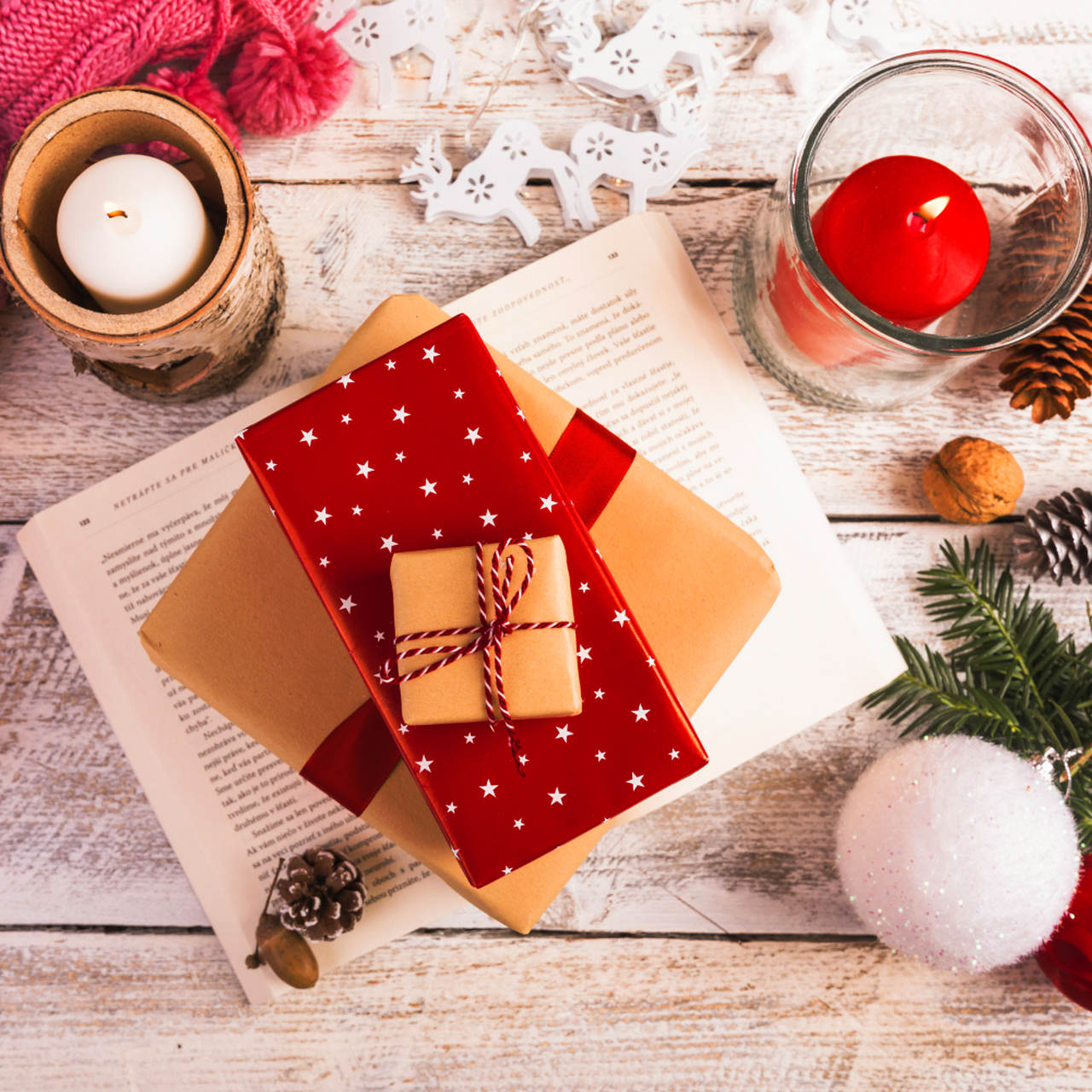 velas, um livro e enfeites de natal para simbolizar livros para dar de presente