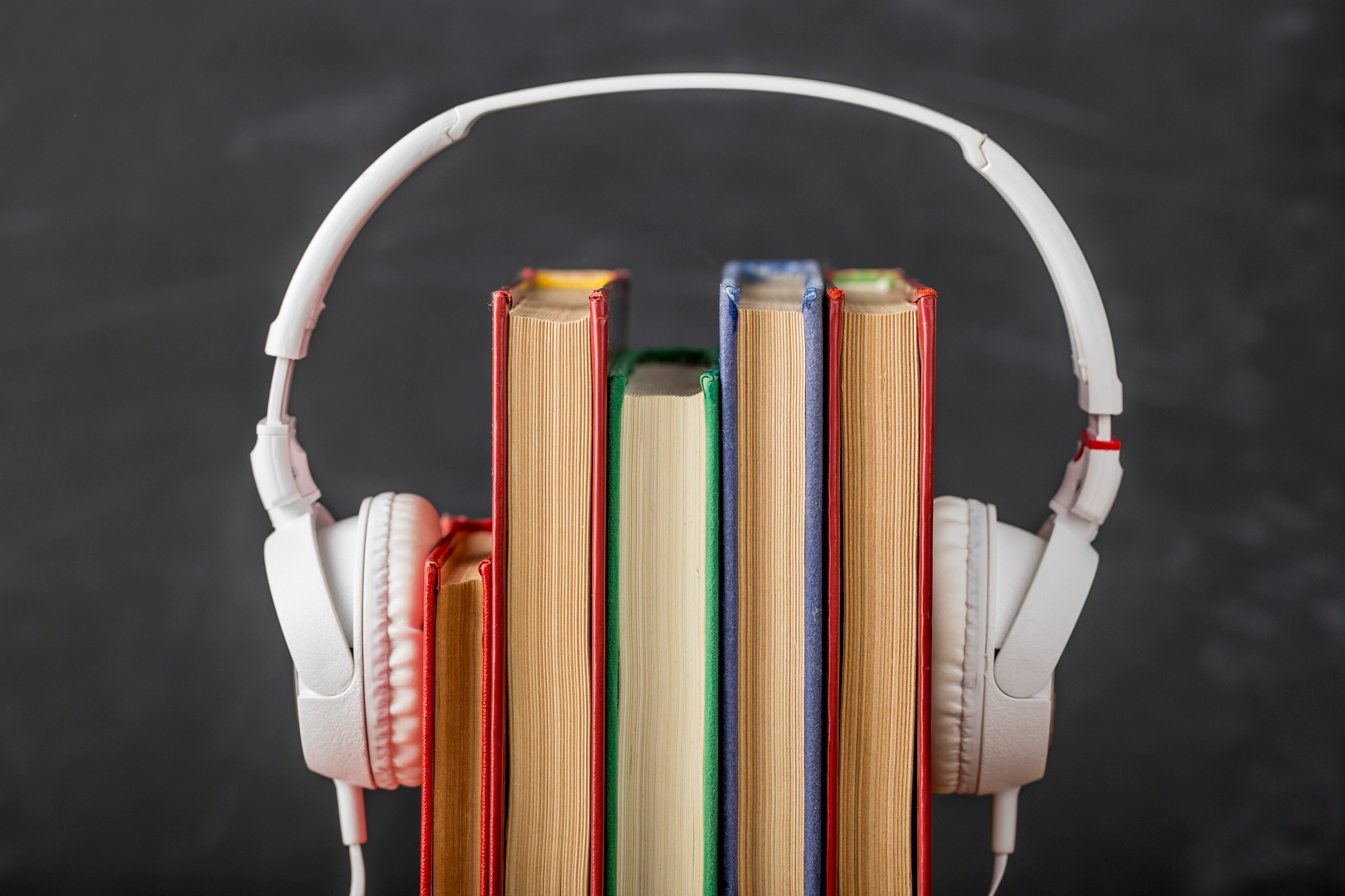 Imagem de livros em volta de um fone de ouido para simbolizar os livros sobre música